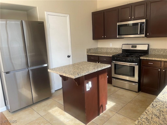 6043 Cape Clairmont Ct, North Las Vegas, NV 89031 - kitchen featuring appliances with stainless steel finishes, dark brown cabinets, light tile patterned floors, and a center island