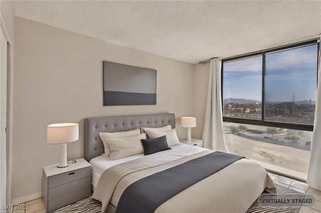 3930 University Center Dr Unit 804, Las Vegas, NV 89119 - tiled bedroom with expansive windows and a textured ceiling