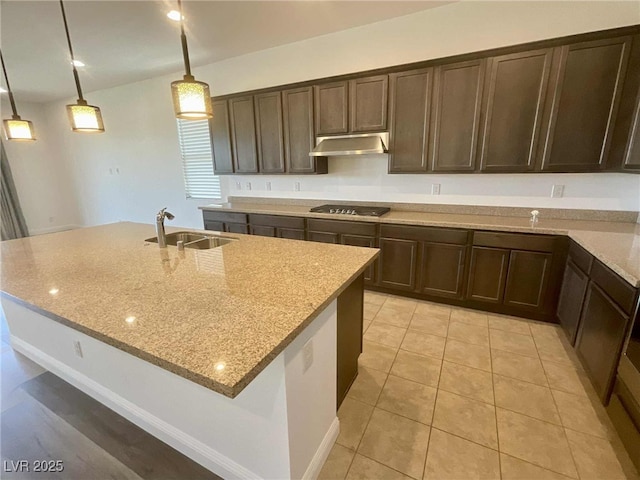 8550 Lost Pony St, Las Vegas, NV 89148 - kitchen featuring under cabinet range hood, cooktop, light stone counters, dark brown cabinetry, and hanging light fixtures