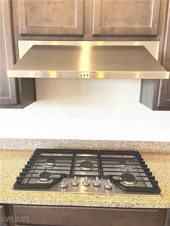 8550 Lost Pony St, Las Vegas, NV 89148 - kitchen view of stainless steel gas cooktop, dark brown cabinetry, and range hood