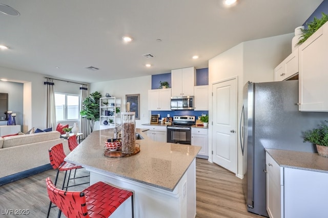 7965 Aurora Sky St Unit 623, North Las Vegas, NV 89084 - kitchen featuring stainless steel appliances, light wood-type flooring, a kitchen bar, white cabinetry, and recessed lighting