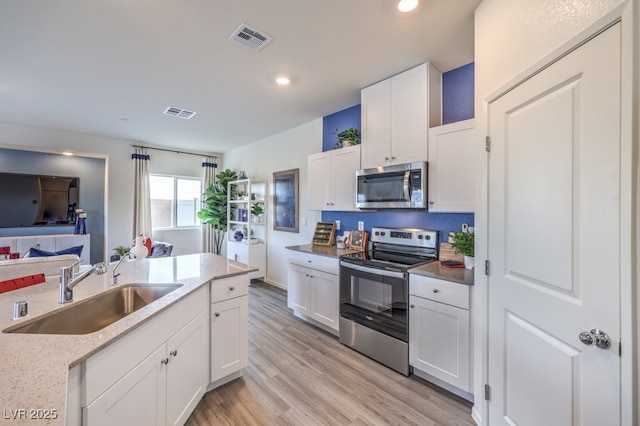 7965 Aurora Sky St Unit 623, North Las Vegas, NV 89084 - kitchen with stainless steel appliances, recessed lighting, white cabinets, light wood finished floors, and light stone counters