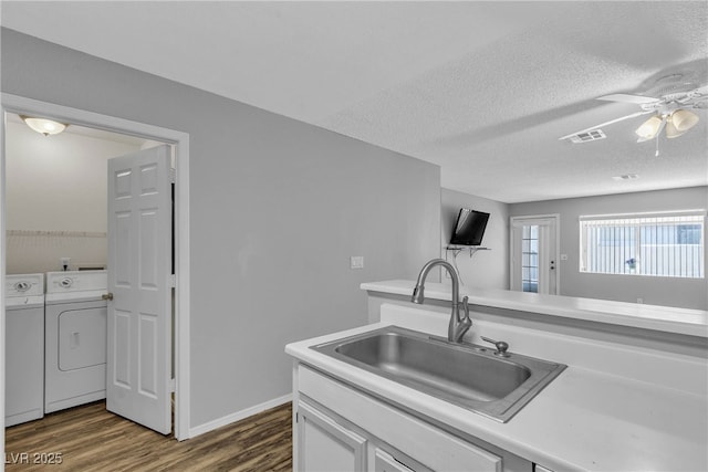 2124 Willowbury Dr Unit D, Las Vegas, NV 89108 - kitchen with washer and dryer, dark wood-type flooring, a ceiling fan, light countertops, and white cabinets
