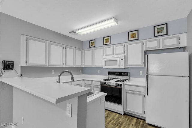 2124 Willowbury Dr Unit D, Las Vegas, NV 89108 - kitchen with white appliances, a peninsula, and white cabinetry