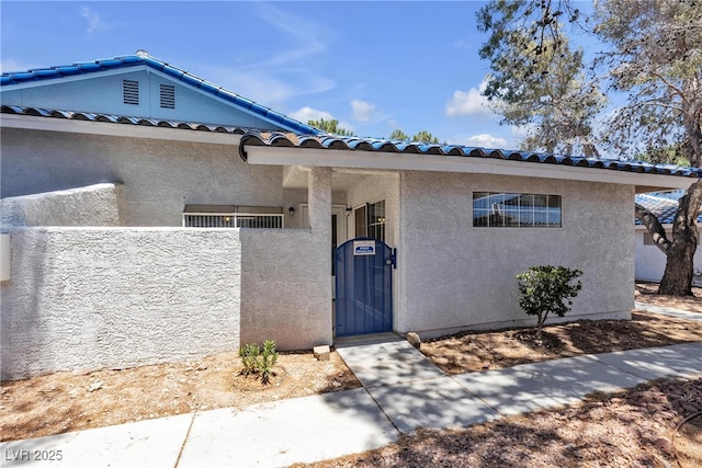 2124 Willowbury Dr Unit D, Las Vegas, NV 89108 - view of front of property featuring a gate, stucco siding, and a tiled roof