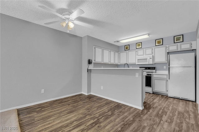 2124 Willowbury Dr Unit D, Las Vegas, NV 89108 - kitchen with white appliances, a textured ceiling, white cabinetry, and dark wood-type flooring