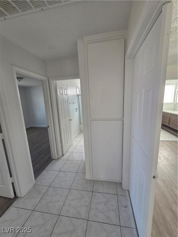 6402 Agua Dr, Las Vegas, NV 89103 - corridor featuring baseboards and light tile patterned flooring
