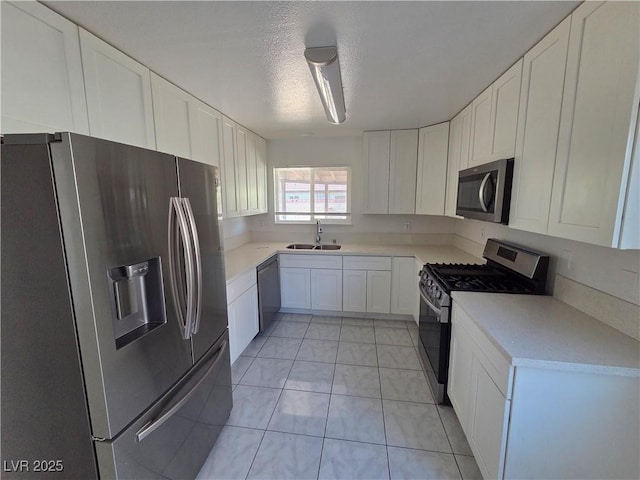 6402 Agua Dr, Las Vegas, NV 89103 - kitchen featuring stainless steel appliances, white cabinets, light countertops, and a textured ceiling