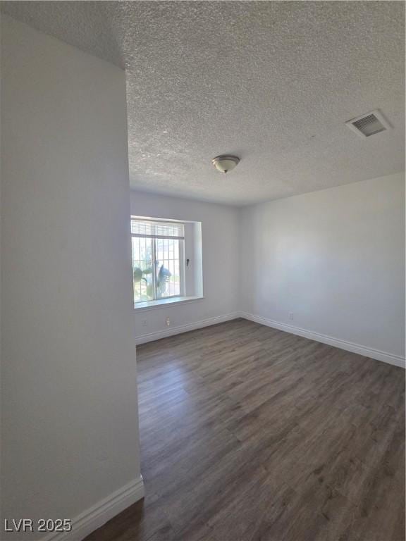 6402 Agua Dr, Las Vegas, NV 89103 - unfurnished room featuring dark wood-style floors and a textured ceiling