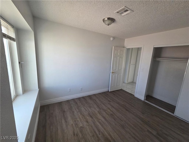 6402 Agua Dr, Las Vegas, NV 89103 - unfurnished bedroom featuring wood finished floors, a textured ceiling, and a closet