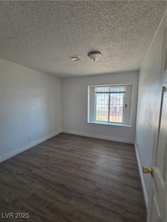 6402 Agua Dr, Las Vegas, NV 89103 - empty room with dark wood-style flooring and a textured ceiling