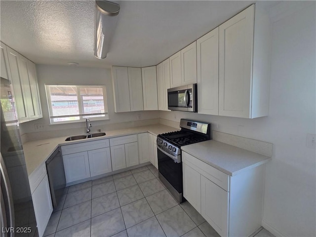 6402 Agua Dr, Las Vegas, NV 89103 - kitchen with appliances with stainless steel finishes, white cabinets, light countertops, a textured ceiling, and light tile patterned floors