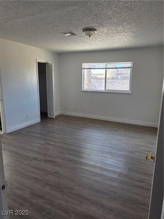 6402 Agua Dr, Las Vegas, NV 89103 - unfurnished room featuring a textured ceiling and dark wood-type flooring