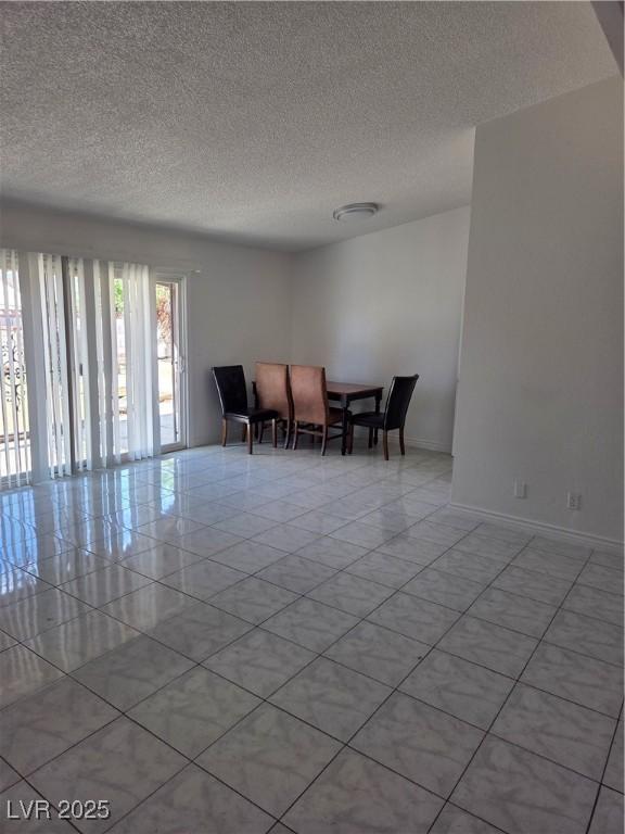6402 Agua Dr, Las Vegas, NV 89103 - dining room featuring a textured ceiling and baseboards