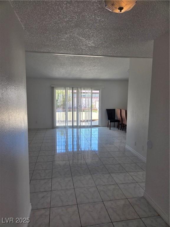 6402 Agua Dr, Las Vegas, NV 89103 - spare room featuring a textured ceiling and light tile patterned flooring