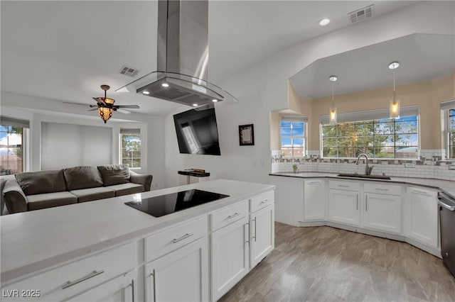 9180 Mohawk St, Las Vegas, NV 89139 - kitchen featuring black electric stovetop, island exhaust hood, tasteful backsplash, plenty of natural light, and recessed lighting