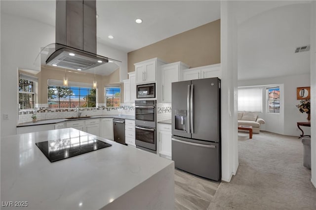9180 Mohawk St, Las Vegas, NV 89139 - kitchen featuring stainless steel appliances, island exhaust hood, white cabinets, backsplash, and recessed lighting