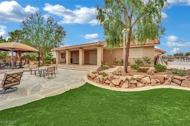 9180 Mohawk St, Las Vegas, NV 89139 - back of property featuring stucco siding, a patio area, a tile roof, a gazebo, and a yard