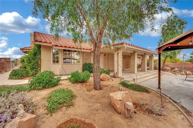 9180 Mohawk St, Las Vegas, NV 89139 - view of front of property with a tile roof, a patio area, and stucco siding