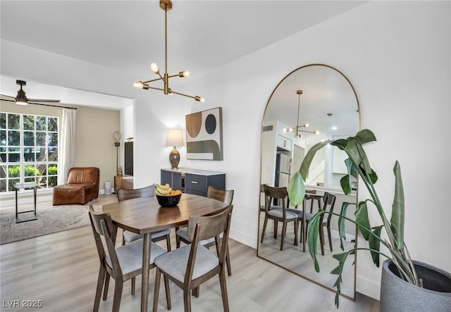 882 Tam O Shanter, Las Vegas, NV 89109 - dining room featuring a chandelier, light wood-style flooring, a ceiling fan, and arched walkways
