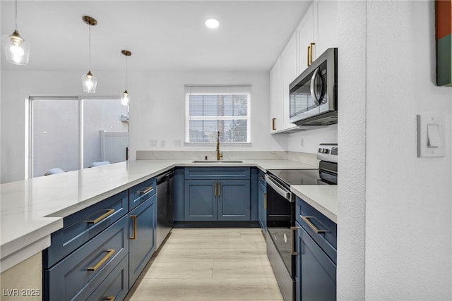 882 Tam O Shanter, Las Vegas, NV 89109 - kitchen with stainless steel appliances, blue cabinetry, light countertops, white cabinetry, and pendant lighting
