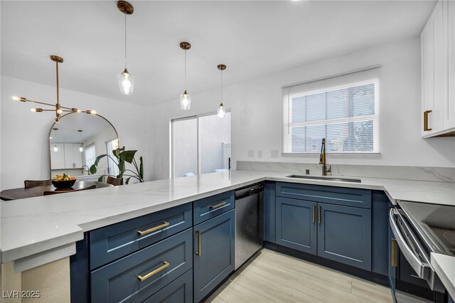 882 Tam O Shanter, Las Vegas, NV 89109 - kitchen featuring appliances with stainless steel finishes, blue cabinets, light stone countertops, a peninsula, and light wood-style floors