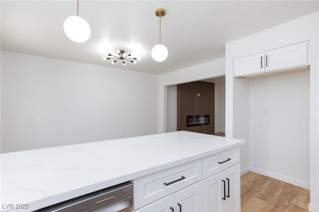 572 Tam O Shanter, Las Vegas, NV 89109 - kitchen featuring white cabinets, decorative light fixtures, light wood-style floors, and light stone counters