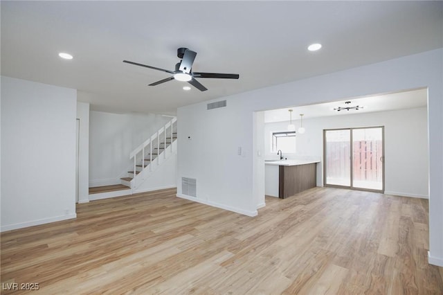 572 Tam O Shanter, Las Vegas, NV 89109 - unfurnished living room with stairway, light wood-style floors, ceiling fan, and recessed lighting