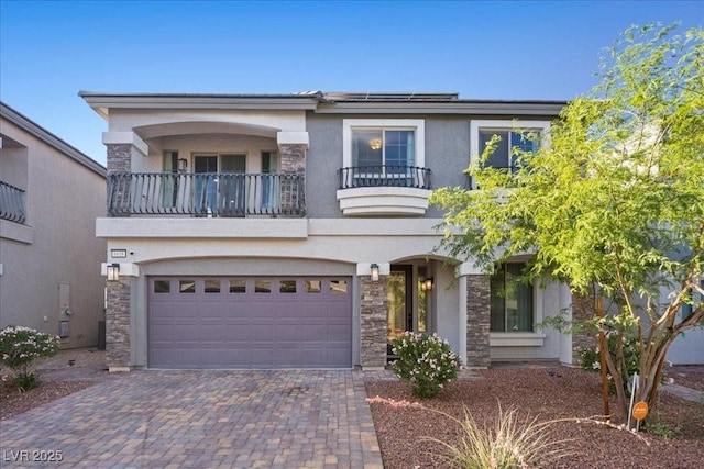 6618 Tangled Vines Ave, Las Vegas, NV 89139 - view of front of house with a balcony, stucco siding, stone siding, a garage, and decorative driveway