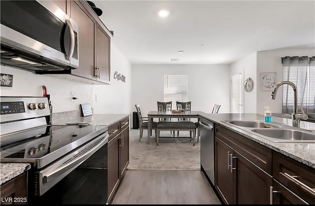 6953 Midnight Bronze St, North Las Vegas, NV 89086 - kitchen with appliances with stainless steel finishes, dark brown cabinets, plenty of natural light, and light countertops