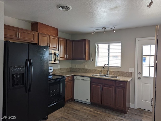 1220 Toledo St, Henderson, NV 89015 - kitchen with black appliances, a textured ceiling, dark wood-type flooring, and light countertops