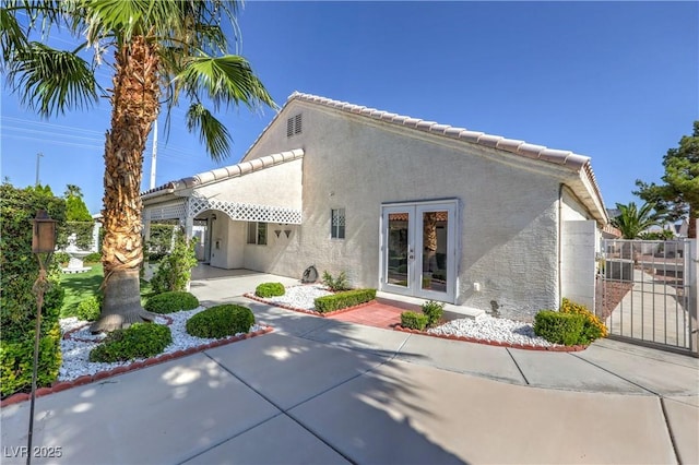 5425 Thomaston Ct, Las Vegas, NV 89122 - rear view of property featuring french doors, stucco siding, a patio area, a gate, and a tile roof