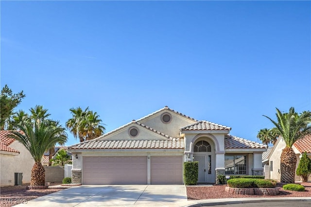 5425 Thomaston Ct, Las Vegas, NV 89122 - mediterranean / spanish-style house featuring driveway, an attached garage, stucco siding, and a tile roof