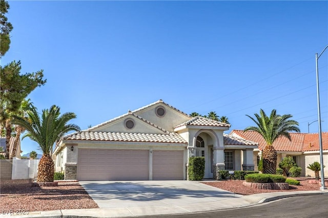 5425 Thomaston Ct, Las Vegas, NV 89122 - mediterranean / spanish-style house featuring an attached garage, driveway, stucco siding, and a tile roof
