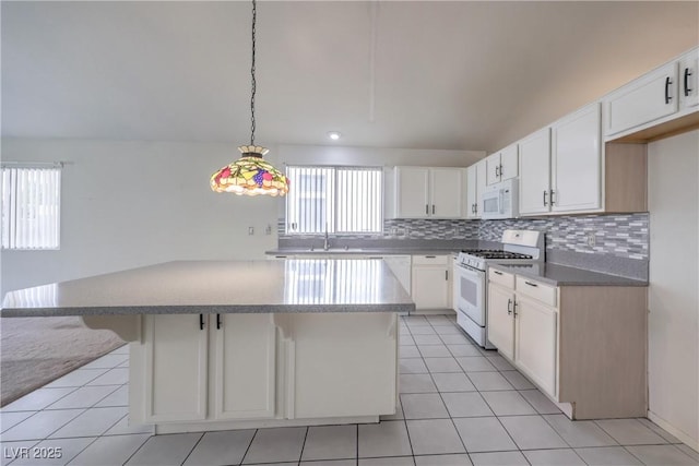 5425 Thomaston Ct, Las Vegas, NV 89122 - kitchen with white appliances, backsplash, a center island, and white cabinets