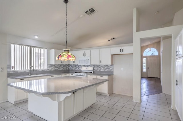 5425 Thomaston Ct, Las Vegas, NV 89122 - kitchen featuring white appliances, a center island, tasteful backsplash, and white cabinetry