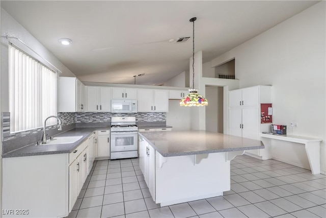 5425 Thomaston Ct, Las Vegas, NV 89122 - kitchen featuring white appliances, decorative backsplash, vaulted ceiling, a kitchen island, and light tile patterned floors