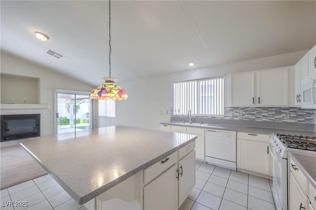 5425 Thomaston Ct, Las Vegas, NV 89122 - kitchen featuring white appliances, light tile patterned floors, a kitchen island, open floor plan, and vaulted ceiling