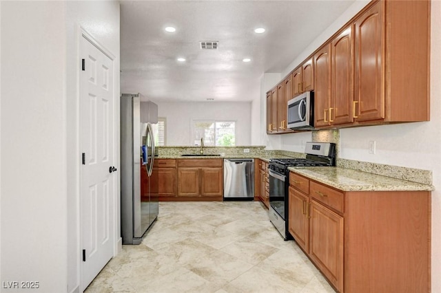 2149 Kelsey Creek Ct, Henderson, NV 89044 - kitchen with stainless steel appliances, light stone countertops, recessed lighting, and brown cabinetry