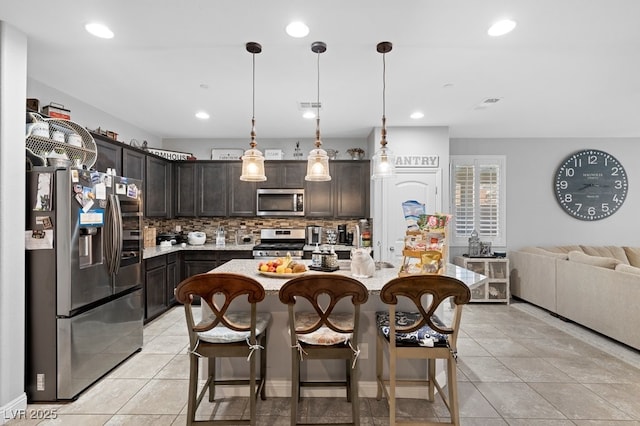 145 Langley Hill Ave, Henderson, NV 89002 - kitchen featuring appliances with stainless steel finishes, decorative backsplash, dark brown cabinetry, light tile patterned floors, and recessed lighting
