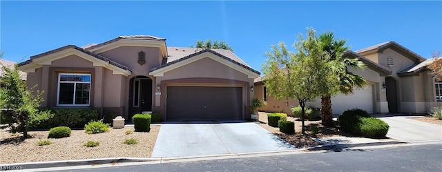 7395 Howell Mill Ct, Las Vegas, NV 89113 - view of front of home with an attached garage, stucco siding, concrete driveway, and a tile roof