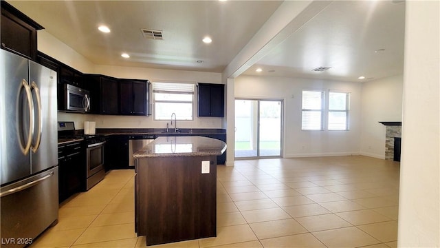 145 Forest Crossing Ct, Las Vegas, NV 89148 - kitchen with appliances with stainless steel finishes, a kitchen island, light tile patterned floors, dark stone counters, and recessed lighting
