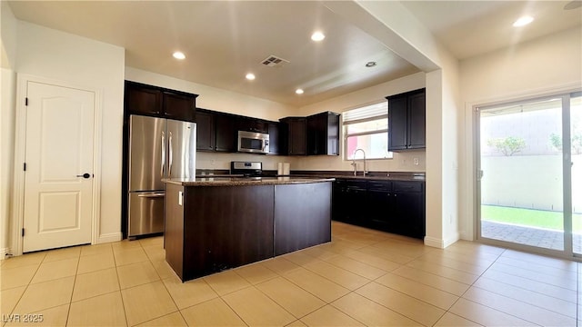 145 Forest Crossing Ct, Las Vegas, NV 89148 - kitchen with appliances with stainless steel finishes, a kitchen island, light tile patterned flooring, recessed lighting, and dark brown cabinetry