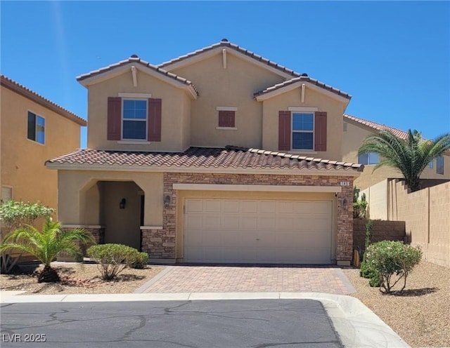 145 Forest Crossing Ct, Las Vegas, NV 89148 - view of front facade featuring a tiled roof, an attached garage, decorative driveway, stucco siding, and stone siding