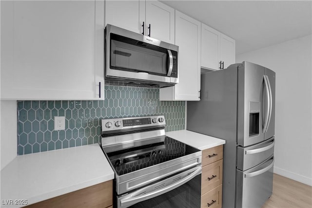 1108 Putnam Ave, North Las Vegas, NV 89030 - kitchen featuring appliances with stainless steel finishes, light countertops, white cabinetry, and backsplash