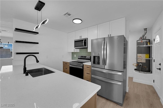 1108 Putnam Ave, North Las Vegas, NV 89030 - kitchen with appliances with stainless steel finishes, secured water heater, light countertops, light wood-type flooring, and tasteful backsplash