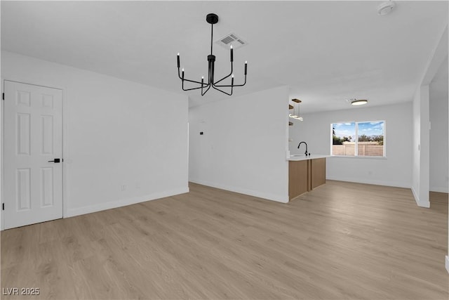 1108 Putnam Ave, North Las Vegas, NV 89030 - unfurnished living room featuring a chandelier and light wood finished floors
