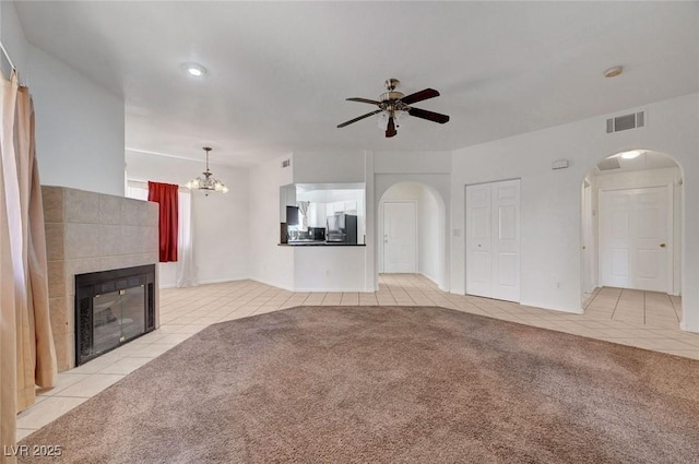 900 Heavenly Hills Ct Unit 114, Las Vegas, NV 89145 - unfurnished living room featuring light tile patterned floors, arched walkways, a ceiling fan, a fireplace, and a chandelier