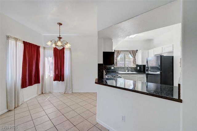 900 Heavenly Hills Ct Unit 114, Las Vegas, NV 89145 - kitchen featuring freestanding refrigerator, a chandelier, backsplash, white cabinets, and range