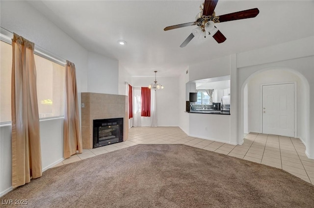 900 Heavenly Hills Ct Unit 114, Las Vegas, NV 89145 - unfurnished living room featuring tile patterned floors, a ceiling fan, carpet floors, a fireplace, and a chandelier